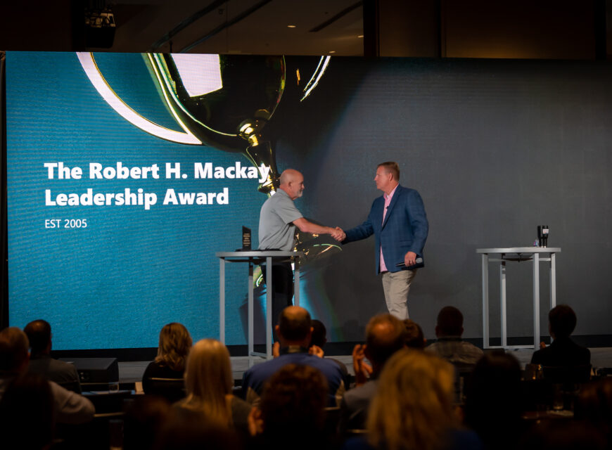 Former CU*Answers CEO Randy Karnes accepts the "Robert H. Mackay" Award from current CEO Geoff Johnson.
